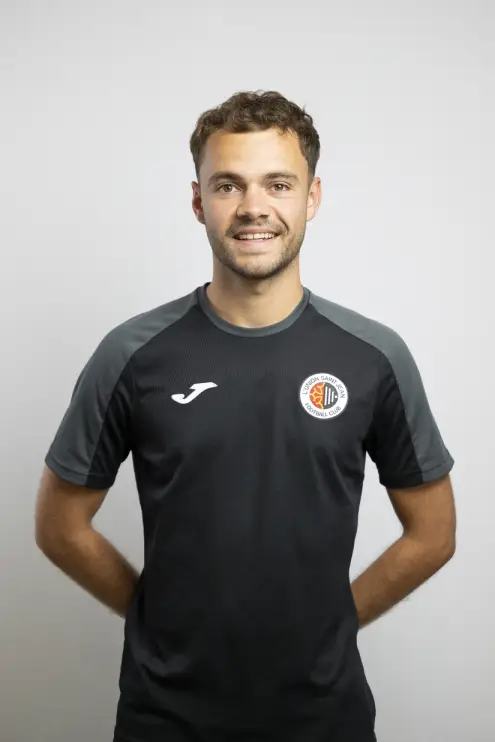 Portrait de Gabin Canac, membre du staff de L’Union Saint-Jean Football Club, en tenue noire Joma avec le logo du club, sur fond clair.