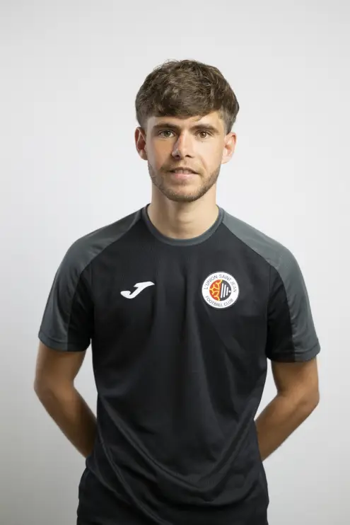 Portrait d’Anthony Calvayrac, membre du staff de L’Union Saint-Jean Football Club, en tenue noire Joma avec le logo du club, sur fond clair.